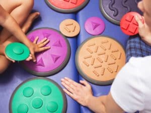 ילדים ממששים משטחי משחק צבעוניים במרקמים שונים. ב - INDEKIDS תוכלו למצוא מגוון של מטפלים באמצעות משחק>>>