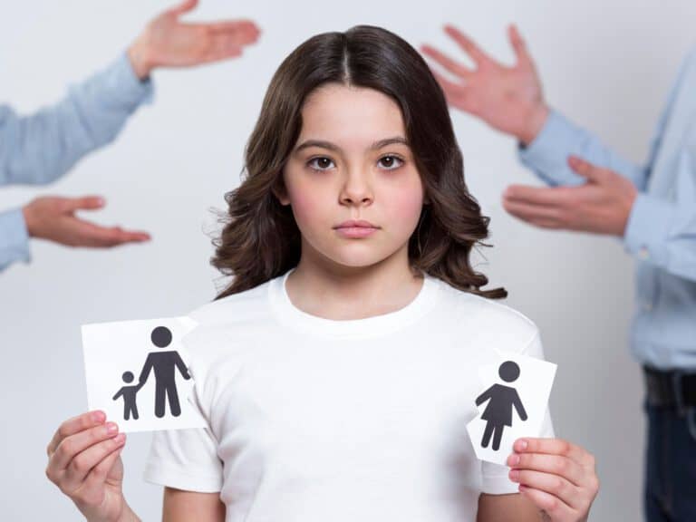 ילדה מחזיקה תמונה של הורה ביד אחת, תמונה של הורה וילד ביד השנייה.