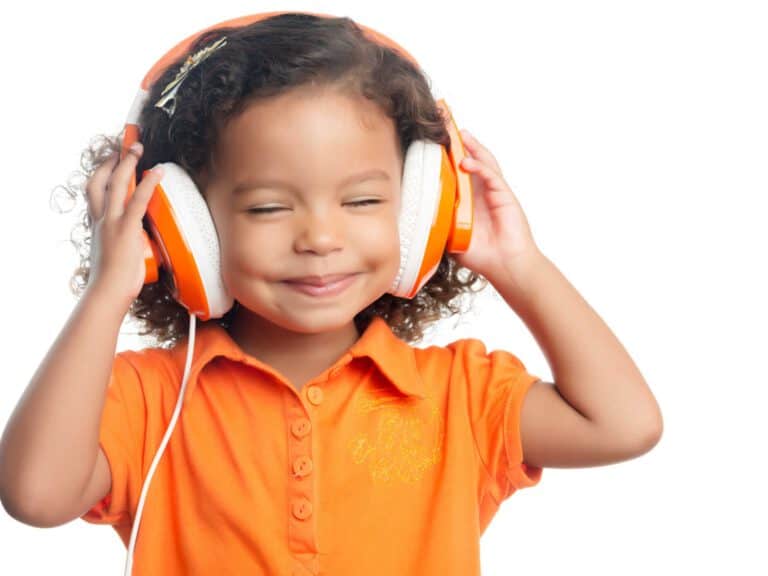 ילד מאושר עם חיוך כשלאוזניו אוזניות. ב - Indekids תמצאו מגוון מטפלים באומנויות